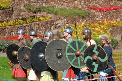 A group of people dressed up in Saxon attire holding a shield and a sword