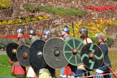 A group of people dressed up in Saxon attire holding a shield and a sword